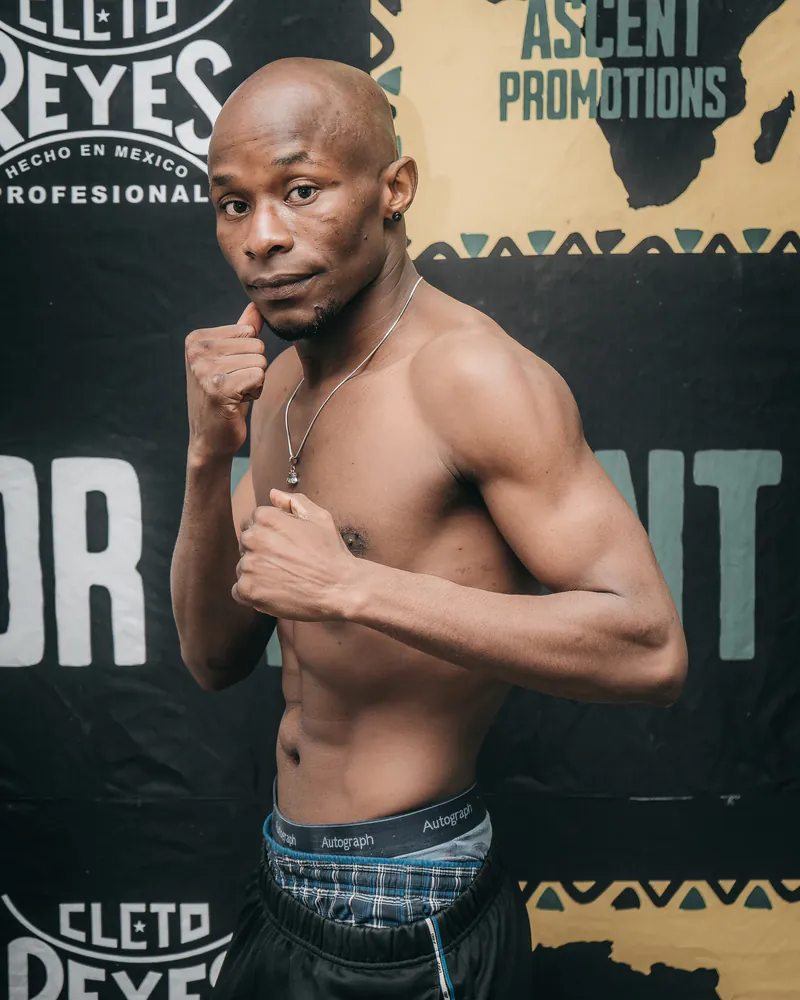 Ardy Katompa holds a compact boxing guard before a Warrior Ascent backdrop