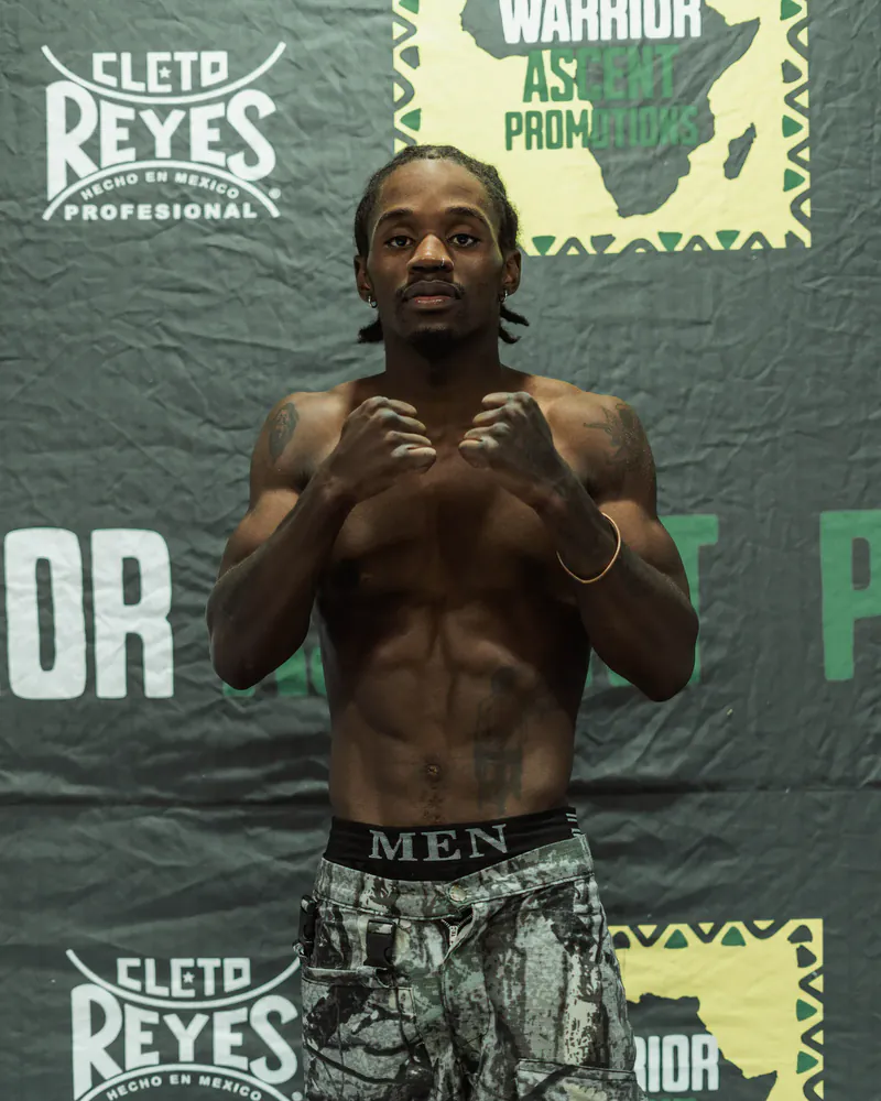 Lebogang Langa faces the camera with both fists raised at a Warrior Ascent portrait session