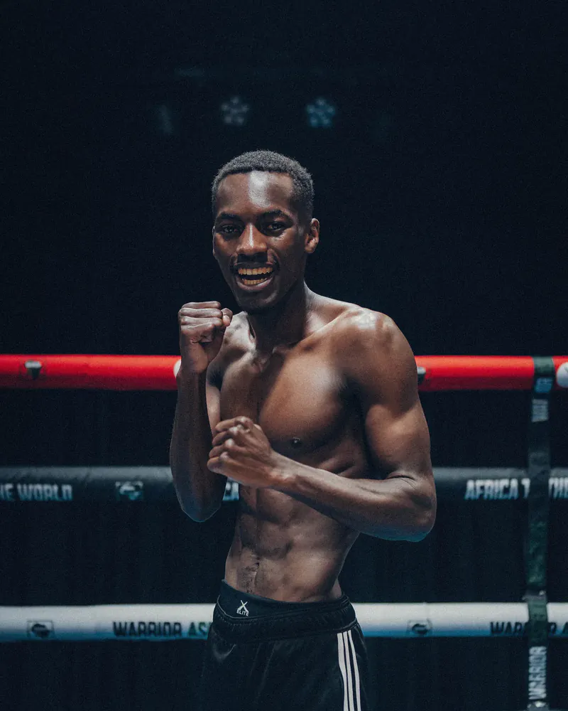 Ndabezinhle Phiri smiles in a boxing stance inside the ring