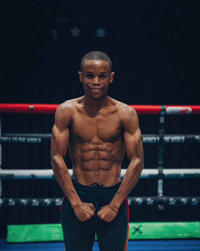 Thando Mthembu poses front-on inside a boxing ring