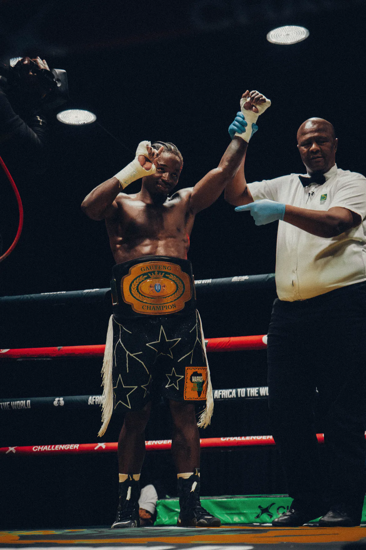 The referee raises Lebogang Langa's hand as he wears the Gauteng championship belt