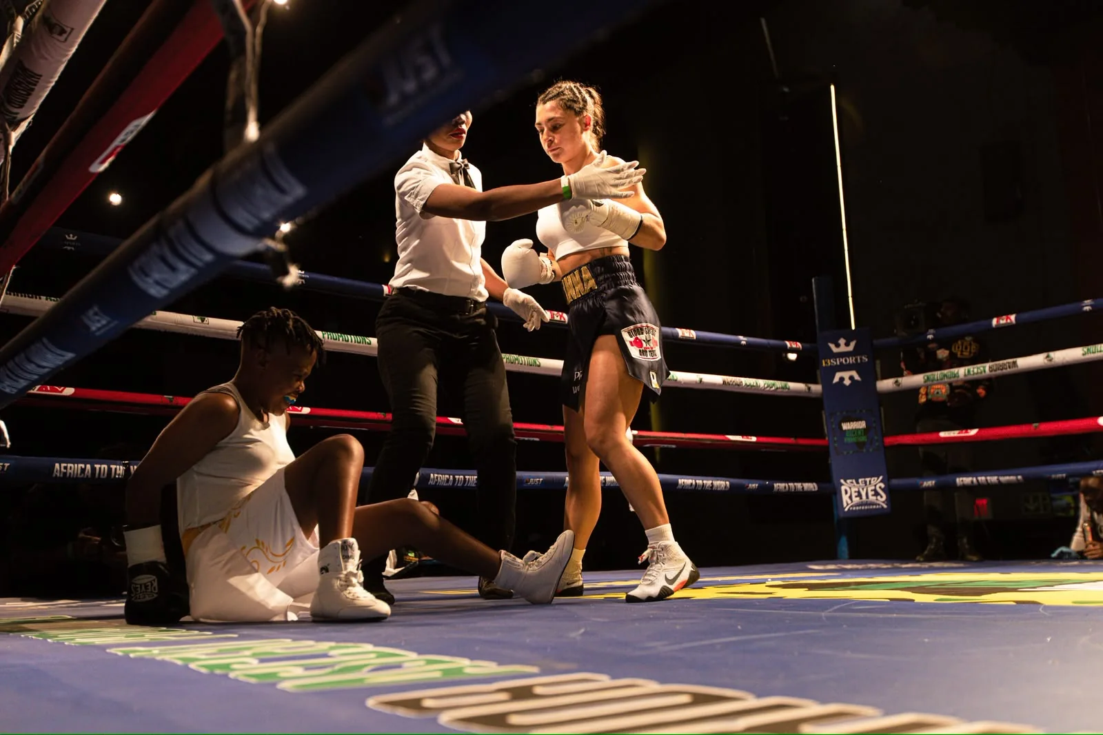 A referee steps between two boxers inside a Warrior Ascent ring